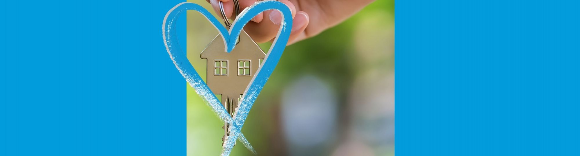 hand holding key shaped like a house, surrounded in a blue heart.