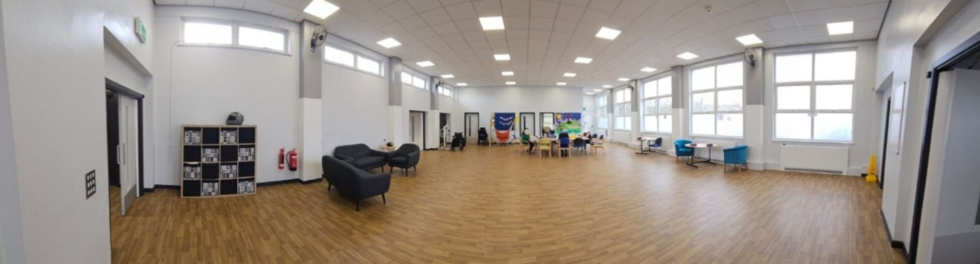 A picture of the room with chairs, sofas and storage cubes