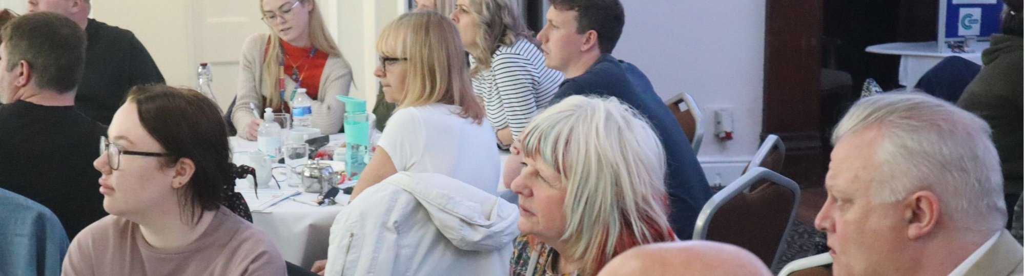 photo of people in a meeting all listening to someone out of shot